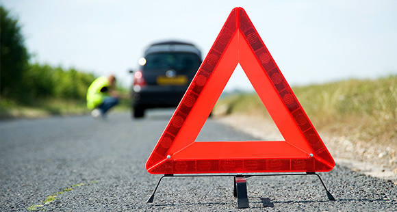 a red warning triangle set out behind a broken down car
